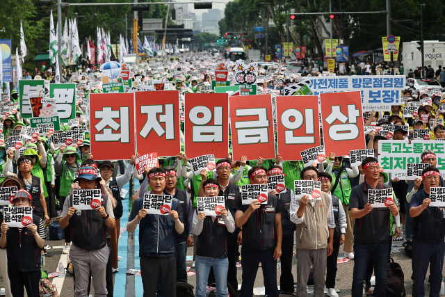 ▲ 지난 24일 서울 혜화역 인근에서 열린 ‘윤석열 정권 퇴진 전국노동자대회’에서 민주노총 회원들이 최저임금 인상 등을 촉구하는 손 피켓을 들어 보이고 있다. [연합뉴스 자료사진]