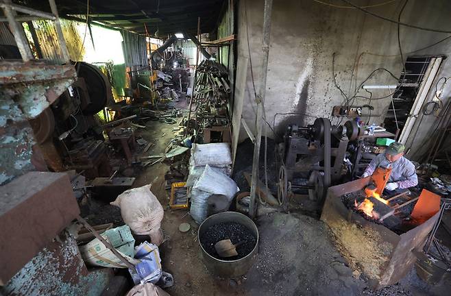 전통 끌 김원태 장인이 단조작업을 하고 있다. 끌의 모양을 만드는 첫 작업인 단조작업은 1000도가 넘는 고열의 화덕 앞에서 하루 종일 한다. 작업실에서 세월의 흔적이 보인다.