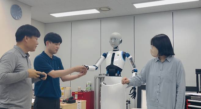 경기도 안산 한국생산기술연구원 융합기술연구소에서 ‘로봇 박사’ 이동욱 수석연구원과 이덕연 선임연구원, 로봇이 학습한 지휘 동작의 주인공인 정예지 지휘자가 에버6의 지휘를 살피고 있다. [사진=고승희 기자]