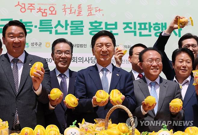 '성주 참외 맛보세요!' (서울=연합뉴스) 이정훈 기자 = 국민의힘 김기현 대표가 9일 오전 국회에서 열린 성주군 농·특산물 홍보 직판행사에서 참외를 들고 기념촬영을 하고 있다. 앞줄 왼쪽부터 국민의힘 정희용 의원, 이성희 농협중앙회장, 김 대표, 윤재옥 원내대표, 이병환 성주군수. 2023.5.9 uwg806@yna.co.kr