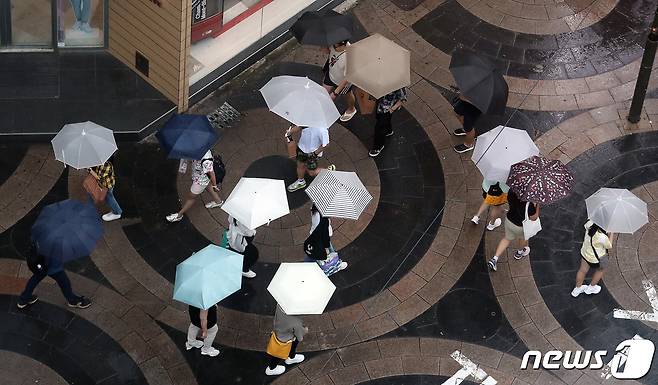 본격적인 장마가 시작된 26일 서울 중구 명동에서 시민들과 외국인 관광객들이 우산을 쓰고 발걸음을 재촉하고 있다. 2023.6.26/뉴스1 ⓒ News1 김진환 기자