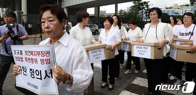 대한간호협회 간호사들이 26일 오전 세종시 어진동 보건복지부 앞에서 간호법 허위사실 유포, 불법진료 묵인 보건복지부 규탄 기자회견을 마친 뒤 간호사면허증 반납과 규탄항의서를 전달하기 위해 복지부 청사로 향하고 있다. 2023.6.26/뉴스1 ⓒ News1 김기남 기자