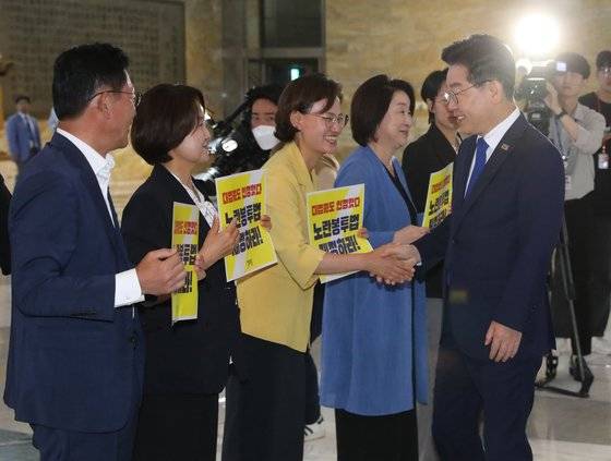 이재명 더불어민주당 대표가 19일 오전 서울 여의도 국회 로텐더홀에서 노란봉투법 처리 촉구 피케팅을 하고 있는 정의당 의원들과 인사하고 있다. 뉴스1