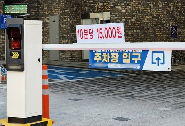 인천시 남동구 한 오피스텔 주차장 입구에 '10분당 1만5000원'이라고 적힌 요금 안내문이 부착돼 있다. 연합뉴스