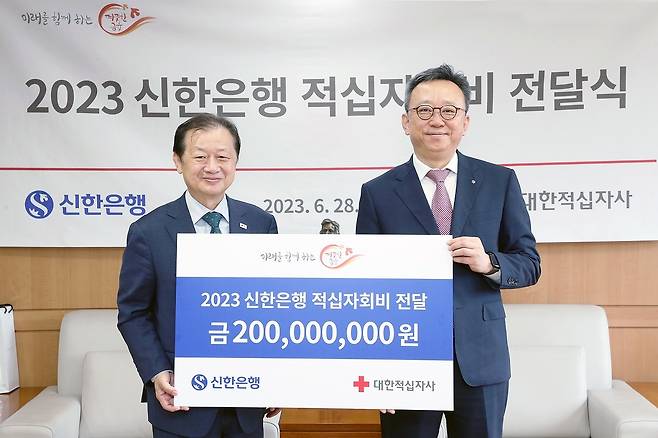 28일 서울 중구 소재 대한적십자사 본사에서 열린 전달식에서 정상혁 신한은행장(우측)과 신희영 대한적십자사 회장이 기념촬영을 하고 있다. (신한은행 제공)