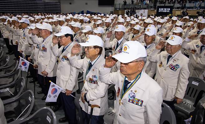 지난 25일 오전 서울 중구 장충체육관에서 열린 6.25 73주년 행사에 참석한 참전용사들이 국가보훈부에서 올해부터 지급한 '영웅의 제복'을 입고 국기에 경례하고 있다. /연합뉴스