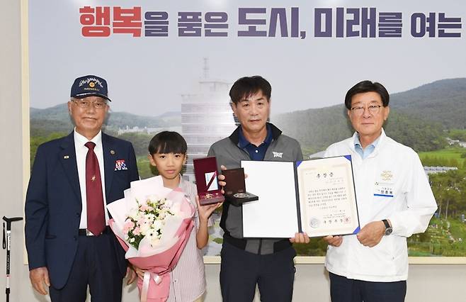 정종복 부산 기장군수(왼쪽 네 번째)가 지난 27일 6.25참전용사 유족에게 화랑무공훈장을 전수한 가운데 관계자들과 기념촬영을 하고 있다. 사진제공ㅣ부산 기장군