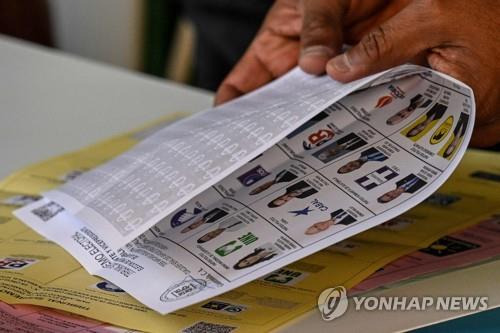 과테말라 대선 투표 (산후안사카테케페스[과테말라] AFP=연합뉴스) 25일(현지시간) 과테말라 산후안사카테케페스에서 한 유권자가 투표용지를 반으로 접고 있다. 2023.6.26