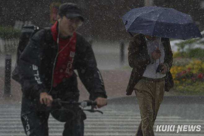 수도권 전역에 호우주의보가 발효된 29일 오후 서울 송파구 잠실역 인근거리에서 우산을 쓴 시민들이 발걸음을 재촉하고 있다.