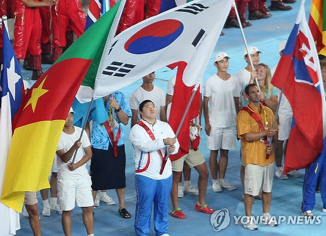 <올림픽>자랑스런 장미란 (베이징=연합뉴스) 김주성 기자 = 24일 베이징올림픽 주경기장에서 열린 폐막행사에서 역도 금메달 리스트인 장미란이 한국을 대표하는 기수로 입장, 태극기를 바라보고 있다.이번 올림픽에서 한국은 금메달 13개, 은메달 10개, 동메달 8개를 획득 종합순위에서 7위를 차지하는 성과를 이뤘으며 다음 올림픽은 런던에서 열린다. emailid@yna.co.kr