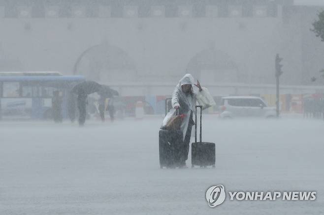 장맛비에 난감해진 서울 여행 (서울=연합뉴스) 김주성 기자 = 장맛비가 거세진 29일 오전 우의를 입은 한 외국인 여행객이 여행 가방을 끌고서 광화문광장을 걸어가고 있다. 2023.6.29 utzza@yna.co.kr