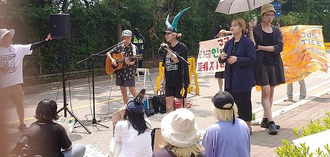 지난 6월 23일 화성 외국인보호소 앞에서 열린 ‘버스 타고 찾아가는 외국인보호소 폐지 문화제’에 참가한 인디밴드 빌리 카터가 랩 공연을 하는 동안 옆에서는 수어 통역이 동시에 진행됐다. 조일준 선임기자