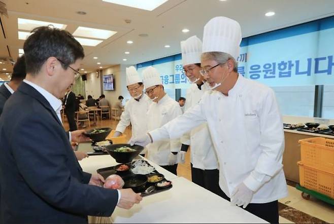 임종룡 회장이 취임 100일을 앞두고 우리금융 본점 식당에서 직원들에게 직접 점심을 배식하며 임직원들과 소통의 시간을 가지고 있다.   우리금융 제공