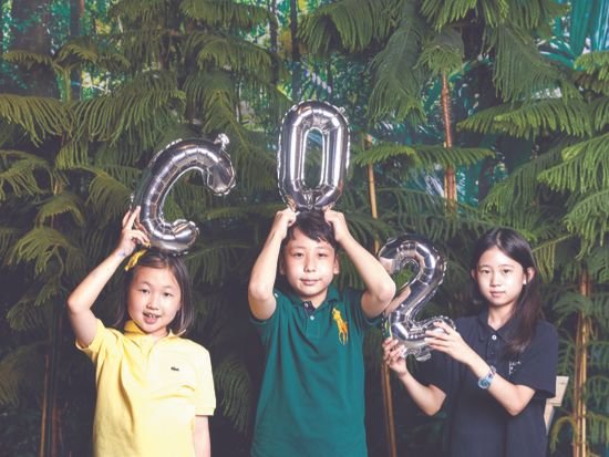 ‘그린카본’ 숲 앞에서 대표적인 온실가스로 꼽히는 이산화탄소(CO2)를 표현해 본 김태연·이예준·박서현(왼쪽부터) 학생모델.