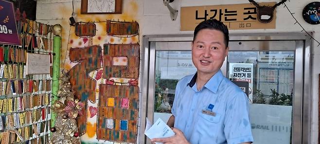 ▲나광선 역장이 방문객들의 꿈과 희망을 기록하고 성취를 기원하는 ‘극락도사’ 체험 코너를 설명하고 있다. 사진 : 필자 촬영