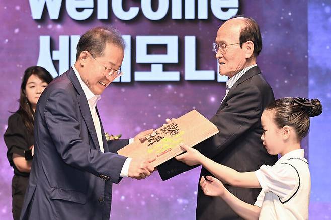 홍준표 시장(왼쪽)이 군위군 주민들로부터 '삼국유사의 고장, 군위'가 적힌 목판을 전달받고 있다. 대구시 제공