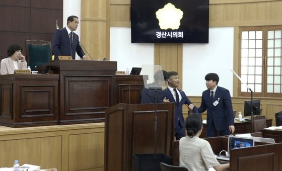 지난달 29일 경북 경산시의회 본회의장에서 더불어민주당 소속 이경원 경산시의원이 5분 발언 중 의회사무처 직원들에 의해 강제 퇴장당하고 있다. 사진 더불어민주당 경북도당