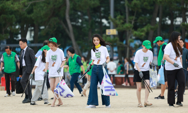 ▲ 김건희 여사가 3일 오후 강릉 경포해변에서 새마을회 회원, 대학생들과 함께 환경정화 활동을 펼치고 있다. 사진/대통령실 공동취재단