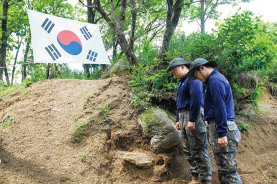 강원도 철원군 734고지에서 유해발굴 시작 전 묵념하고 있는 육군15보병사단 백호대대 양원식(왼쪽)·양민재 병장. 양원식 병장은 유해발굴작전 참여를 위해 전역시계를 늦췄다. 사진 이규정 하사 제공／국방일보