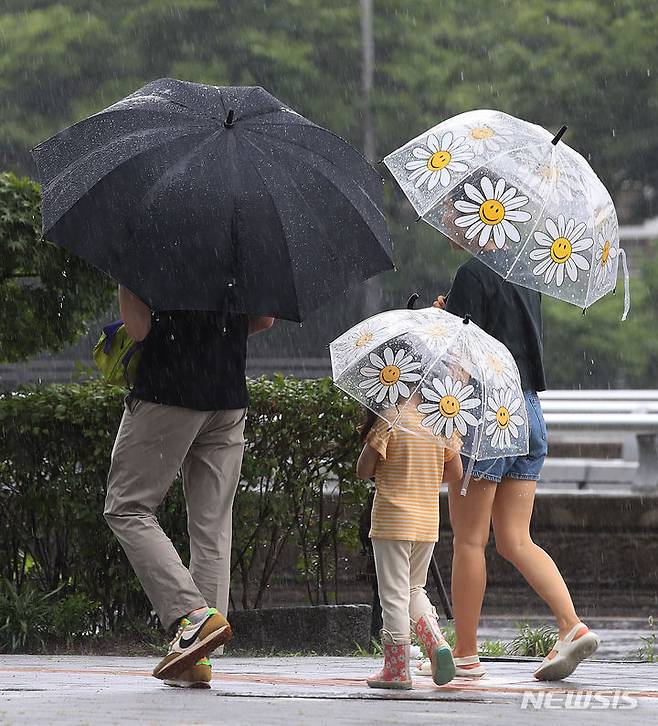 [서울=뉴시스] 조수정 기자 = 전국에 장맛비가 내리고 있는 4일 서울 영등포구 여의도동에서 아이와 엄마아빠가 우산을 들고 걸어가고 있다. 2023.07.04. chocrystal@newsis.com