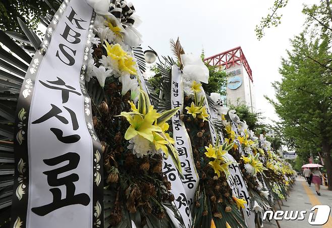 방송통신위원회가 오는 5일 전체회의에서 텔레비전방송수신료(KBS·EBS 수신료)를 전기요금에서 분리 징수하는 내용의 방송법 시행령 개정안을 의결할 것으로 보인다. 현재 방통위는 여야가 2대 1 구도여서 더불어민주당에서 추천한 김현 상임위원이 반대하더라도 가결될 가능성이 크다. 방통위 전체회의에서 의결되면 국무회의 의결, 대통령 재가 등 절차만 남는 만큼 이르면 이달 중순 공포될 수 있다는 전망이 나온다. 사진은 4일 서울 여의도 KBS 앞에 수신료 분리 징수를 촉구하며 놓인 근조 화환의 모습. 2023.7.4/뉴스1 ⓒ News1 신웅수 기자