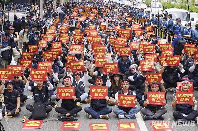 전국민주노동조합총연맹(민주노총) 조합원들이 5일 오후 서울 서대문구 경찰청 앞에서 열린 민주노총 서울지역 총파업 승리 결의대회에서 '윤석열 정권 퇴진 촉구 손피켓'을 들고 구호를 외치고 있다.