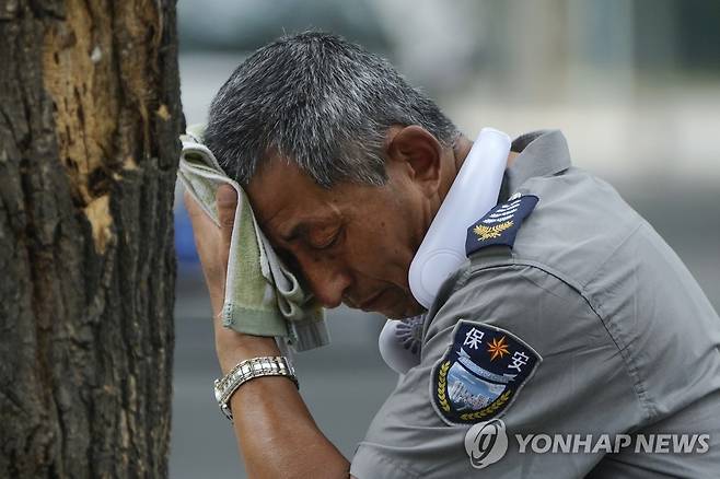 7월 3일 베이징에서 더위를 식히는 보안 요원 [AP=연합뉴스]