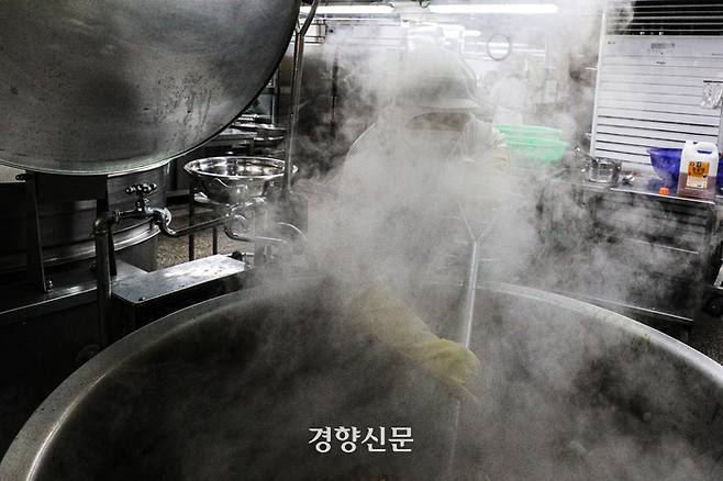 한 급식 조리사가 조리용 삽으로 돼지갈비찜을 뒤집고 있다. 몸보다 큰 솥 앞에 서서 뜨거운 김을 맞으며 삽질을 하는 모습이 힘겨워 보인다. 성동훈 기자