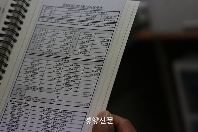 지난달 28일 경남 거제 경남 거제 민주노총 금속노조 거제통영고성조선하청지회 사무실에서 나윤옥씨(55)가 지난 2월 임금명세서를 읽고 있다. 나씨는 2월 한 달 249.5시간 일했지만 225만3976원을 받았다. 10년차 발판공인 나씨의 시급은 9881원이다. 조해람 기자