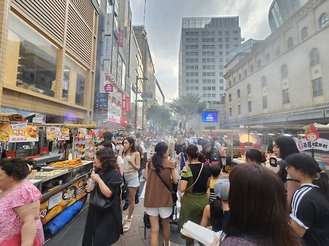 지난 5일 오후 6시 방문한 서울 명동 거리 모습입니다. 해가 지지 않은 시간이지만 많은 관광객들이 노점상에서 음식을 사먹으며 한국 관광을 즐기고 있었습니다. 뿌연 음식 연기와 여러 음식 냄새들이 외국 야시장을 떠올리게 했습니다. 조성민 기자