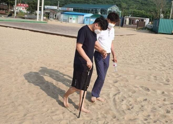 지난 2021년 3월 취업 직후 아스트라제네카 코로나19 백신을 맞고 척수염 등 진단을 받은 김지용씨(왼쪽). 재활 끝에 사지마비 증상은 호전됐으나 지팡이 없이 돌아다니기 힘들며 간질 증상도 심해졌다. 지용씨 아버지&nbsp;김두경 코로나19백신피해자가족협의회(코백회) 회장 제공