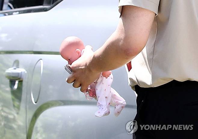 현장 검증에 사용된 아기 모형 (김포=연합뉴스) 김상연 기자 = 6일 오전 경기 김포시 대곶면 한 텃밭 입구에서 경찰이 현장 검증에 사용할 아기 모형을 들고 이동하고 있다. 경찰은 태어난 지 하루 된 영아가 숨지자 출생 신고와 장례 없이 텃밭에 암매장한 혐의(사체유기)로 40대 여성을 긴급체포해 조사 중이다. 2023.7.6 goodluck@yna.co.kr