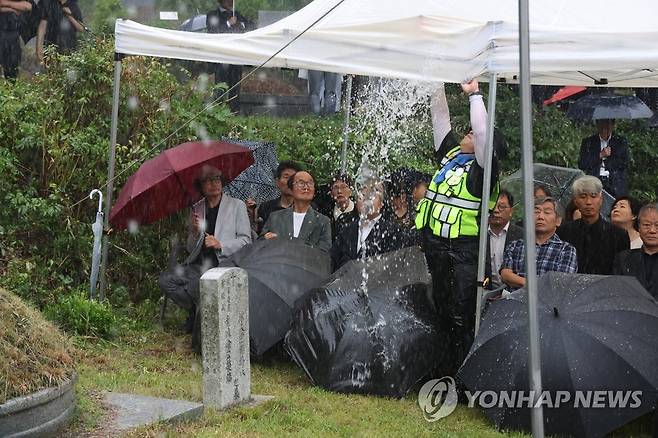 폭우 속에 열린 박원순 추모식 (남양주=연합뉴스) 임병식 기자 = 9일 경기도 남양주시 모란공원에서 열린 고(故) 박원순 전 서울시장 추모제에서 추모객이 천막에 고인 빗물을 빼내고 있다. 
    박원순 전 서울시장의 묘소는 지난 4월 고향인 경남 창녕군에서 모란공원 민주열사 묘역으로 이장됐다. 2023.7.9 andphotodo@yna.co.kr