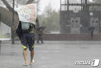 강한 소나기가 내린 9일 서울 광진구 뚝섬유원지를 찾은 나들이객들이 비를 피하고 있다. 2023.7.9/뉴스1 ⓒ News1 김도우 기자