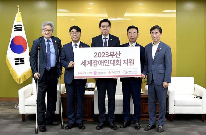 BNK부산은행은 11일 부산시청에서 오는 8월 부산시에서 열리는 ‘2023부산세계장애인대회 지원 전달식’을 갖고 ‘2023부산세계장애인대회 조직위원회’에 후원금 1억원을 전달했다.2023부산세계장애인대회 조창용 부대회장, BNK부산은행 방성빈 은행장, 부산광역시 박형준 시장, 부산사회복지공동모금회 최금식 회장, 2023부산세계장애인대회 조직위원회 오준 공동위원장(왼쪽부터)이 기념촬영을 하고 있다.