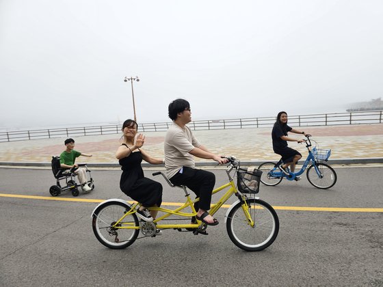 2000년생 동갑내기 친구들이 여수 오동도를 찾아 자전거를 탔다. 박산성(23)씨는 자전거를 탈 수 없었지만 전동 휠체어로 다른 친구들과 오동도를 한 바퀴 돌았다. 이찬규 기자