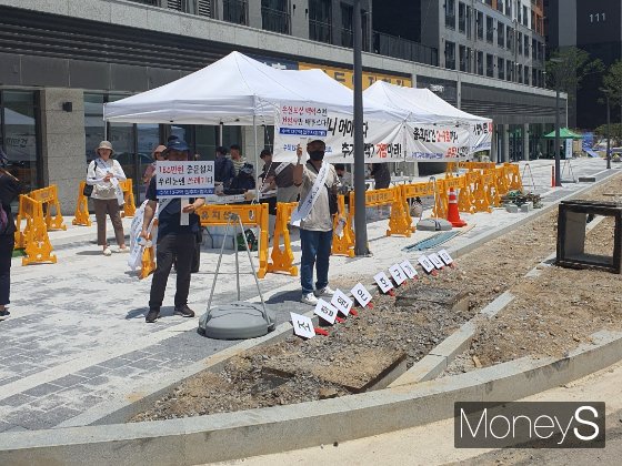 지난 7월1일 열린 조합 임시총회에서 수색13구역 예비입주자협의회가 조합원을 상대로 서면결의 철회서를 받고 있다./사진=정영희 기자