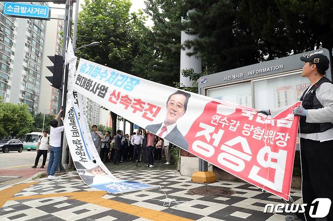 인천 연수구 관계자가 12일 연수구 동춘동 거리에 걸린 정당현수막을 철거하고 있다. 인천시는 지난 8일 정당현수막을 규제하는 내용의 '옥외광고물 조례개정안'을 시행하고 11일까지 계도·홍보기간을 거쳐 12일부터 본격적인 단속을 시작했다. 2023.7.12/뉴스1 ⓒ News1 정진욱 기자