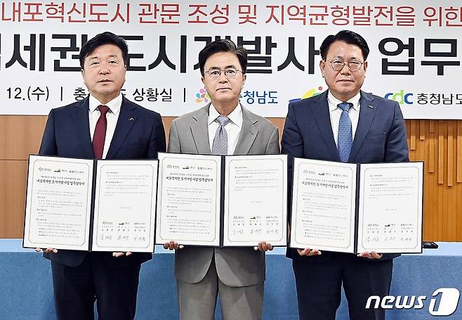 12일 충남도청에서 김태흠 지사(가운데), 최재구 예산군수(왼쪽), 정석완 충남개발공사 사장이 ‘내포혁신도시 관문 조성 및 지역균형발전을 위한 내포역세권 도시개발사업 업무협약’을 체결한 뒤 기념촬영을 하고 있다.(충남도 제공)/뉴스1