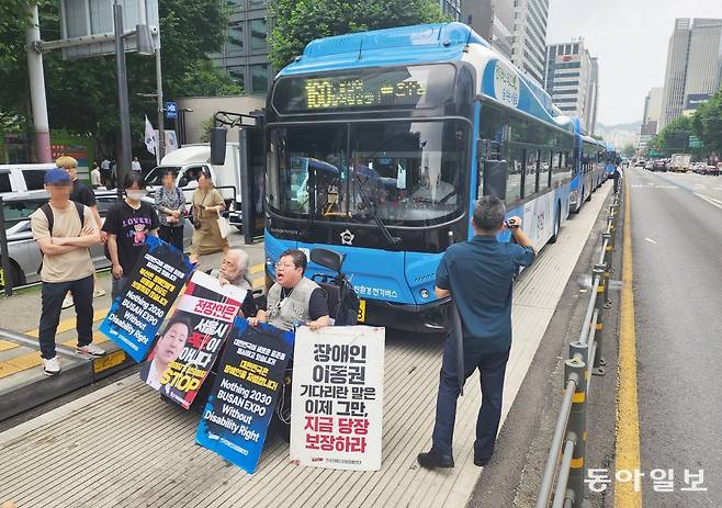 전국장애인차별철폐연대(전장연) 박경석 대표와 활동가들이 12일 점심시간 서울 종로구 종로1가 중앙버스전용차로에서 기습 시위를 벌이고 있다. 최혁중 기자 sajinman@donga.com