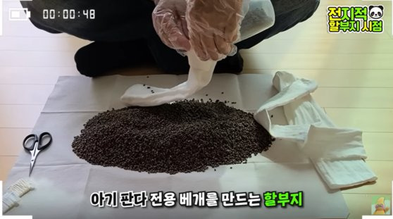 강철원 사육사가 아이바오의 출산을 대비해 아기들을 위한 메밀 베개를 만들고 있다. 유튜브 캡처