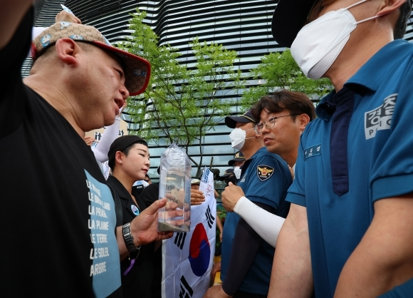 촛불연대 회원들이 지난 8일 오후 서울 종로구 일본대사관 앞에서 직접 후쿠시마 원전 인근 해상에서 떠온 바닷물을 일본대사관 측에 전달하려다 경찰에 가로막히고 있다. 가수 리아(왼쪽에서 두 번째). 연합뉴스