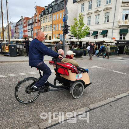지난 5월 24일 덴마크 코펜하겐 뉘하운 인근에서 자원봉사자가 노인 2명을 삼륜자전거에 태우고 산책을 하고 있다.(사진=이소현 기자)