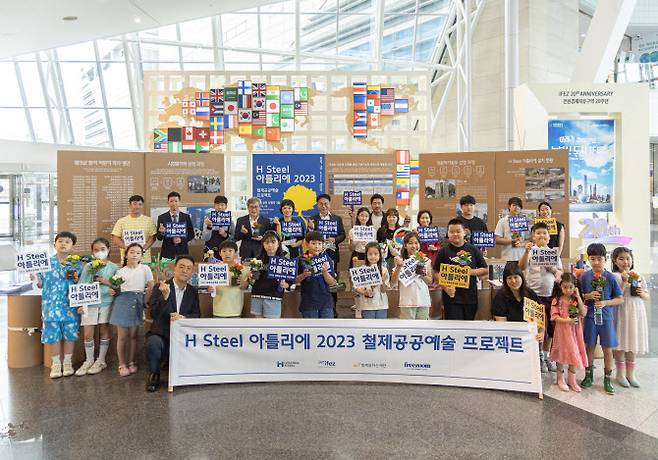 안동일 현대제철 사장(뒷줄 왼쪽에서 여섯번째)이 13일 인천 송도 센트럴파크에 설치된 H-아틀리에 포토월에서 참석자들과 기념촬영을 하고 있다.(사진=현대제철)