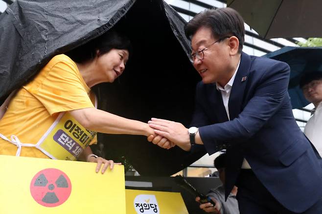 이재명 더불어민주당 대표가 13일 오후 서울 종로구 일본대사관 앞에 마련된 단식농성장을 방문해 후쿠시마 오염수 방류 저지를 위해 18일째 단식 중인 이정미 정의당 대표를 만나 악수를 나누고 있다. (사진= 뉴스1)