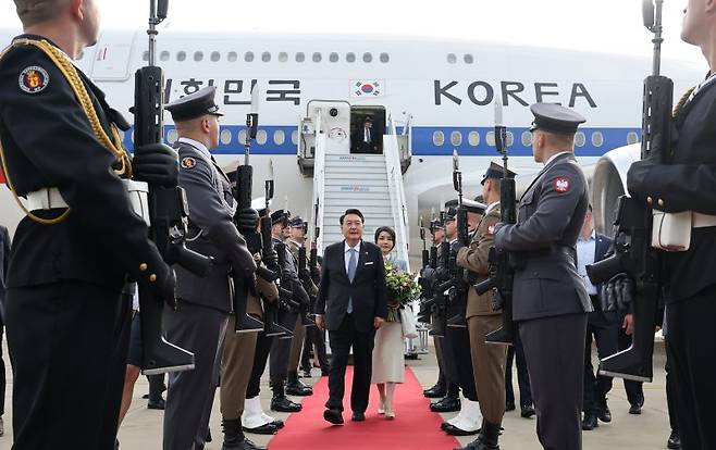 북대서양조약기구(NATO·나토) 정상회의 참석을 마치고 폴란드 공식 방문 일정에 들어가는 윤석열 대통령과 김건희 여사가 12일 오후(현지시간) 바르샤바 쇼팽 국제공항에 도착, 전용기인 공군 1호기에서 내린 뒤 의장대를 사열하고 있다. 연합뉴스