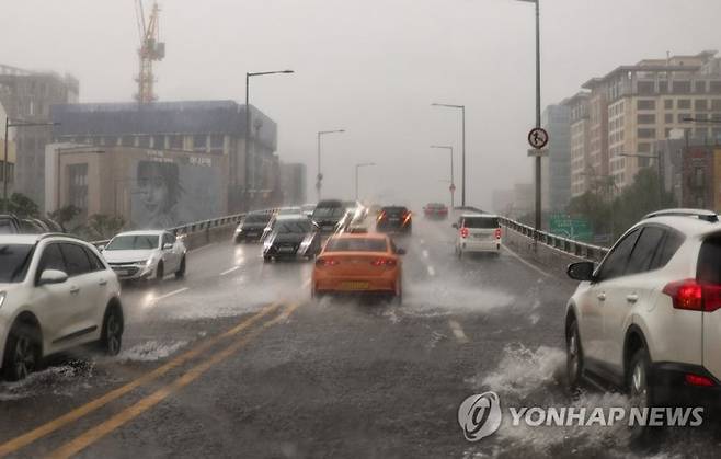 13일 오후 9시를 기해 서울시에 호우경보가 발효됐다. 서울 지역에 폭우가 쏟아지는 가운데 13일 오후 서울 용산구 한남오거리 인근 한남 고가 남단에서 차오른 빗물에 차량이 서행 운전하고 있다. 연합뉴스