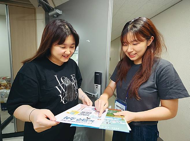 우선주(오른쪽)씨가 기숙사 거주 주민에게 동 주민센터 자료를 보여주고 있다.