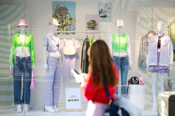 A passerby looks at a clothing shop near Hongik University. [WOO SANG-JO]