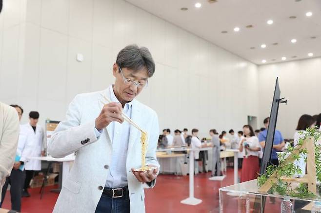 농심 신동원 회장이 사내 아이디어공모전 '챌린지페어'에서 연구원들이 만든 시제품을 시식하고 있다. 농심